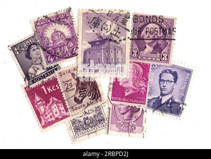 Lila Briefmarken aus aller Welt auf weißem Hintergrund. Stockfoto