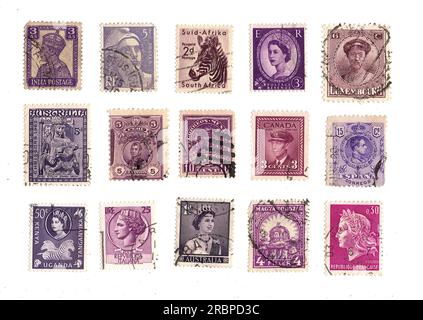 Lila Briefmarken aus aller Welt auf weißem Hintergrund. Stockfoto