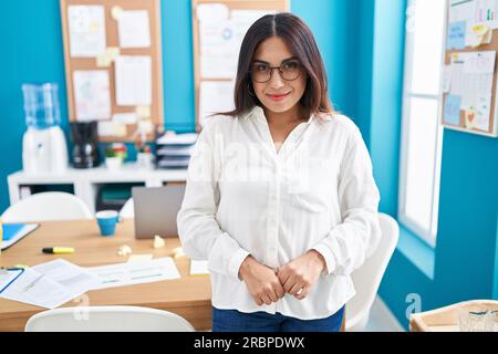 Junge, wunderschöne arabische Geschäftsfrau, die selbstbewusst im Büro lächelt Stockfoto