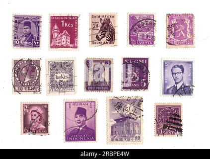 Lila Briefmarken aus aller Welt auf weißem Hintergrund. Stockfoto