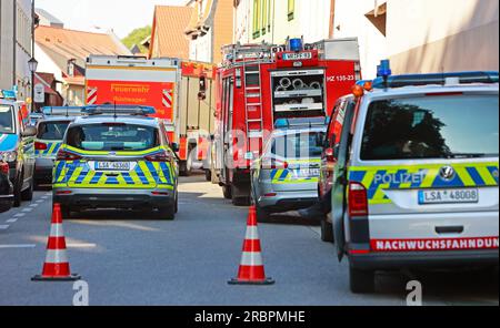 Wernigerode, Deutschland. 10. Juli 2023. Einsatzfahrzeuge der Feuerwehr und der Polizei stehen im Bereich der weit abgesperrten Polizeistation im Stadtzentrum. Die Polizeistation und der benachbarte Nicolaiplatz wurden teilweise evakuiert. Der Grund war ein Umschlag mit pulverförmigen Substanzen, zusätzlich zu einem mehrseitigen Brief, sagte die Polizei. Nach einer ersten Prüfung durch die Feuerwehr konnte nicht ausgeschlossen werden, dass es sich um giftige Substanzen handelte. Kredit: Matthias Bein/dpa/Alamy Live News Stockfoto
