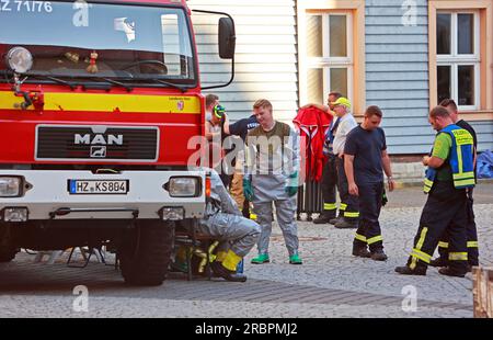 Wernigerode, Deutschland. 10. Juli 2023. Feuerwehrleute und Polizisten stehen im Bereich der weithin abgesperrten Polizeistation im Stadtzentrum. Die Polizeistation und der benachbarte Nicolaiplatz wurden teilweise evakuiert. Der Grund war ein Umschlag mit pulverförmigen Substanzen, zusätzlich zu einem mehrseitigen Brief, sagte die Polizei. Nach einer ersten Prüfung durch die Feuerwehr konnte nicht ausgeschlossen werden, dass es sich um giftige Substanzen handelte. Kredit: Matthias Bein/dpa/Alamy Live News Stockfoto