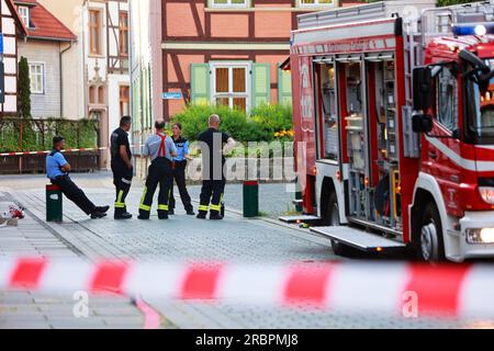 Wernigerode, Deutschland. 10. Juli 2023. Feuerwehrleute und Polizisten stehen im Bereich der weithin abgesperrten Polizeistation im Stadtzentrum. Die Polizeistation und der benachbarte Nicolaiplatz wurden teilweise evakuiert. Der Grund war ein Umschlag mit pulverförmigen Substanzen, zusätzlich zu einem mehrseitigen Brief, sagte die Polizei. Nach einer ersten Prüfung durch die Feuerwehr konnte nicht ausgeschlossen werden, dass es sich um giftige Substanzen handelte. Kredit: Matthias Bein/dpa/Alamy Live News Stockfoto