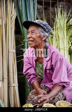 Eine weibliche Marktbesitzerin mit ihrem Morgentee auf den Gianyar-Märkten in Bali Indonesien. Stockfoto