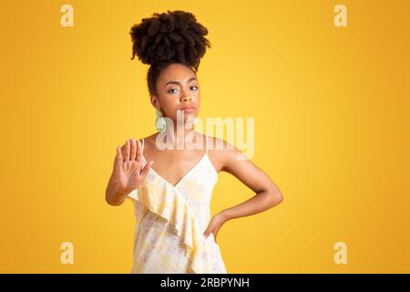 Ernsthafte, streng zuversichtliche afroamerikanische Millennials-Frau, die ihre Hand vor die Kamera hält Stockfoto