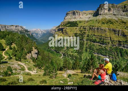 Wandern von Mann und Frau machen Sie eine Pause und schauen Sie sich den spanischen Grand Canyon im Ordesa Valley, Rio Arazas Valley, Ordesa Valley, Ordesa y Monte Perdid an Stockfoto
