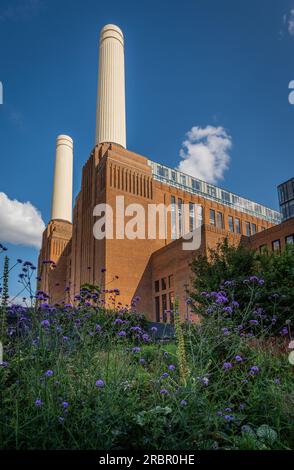 Battersea, London, Vereinigtes Königreich: Battersea Power Station wurde als Einkaufs- und Freizeitziel neu entwickelt. Porträtansicht mit Blumen im Vordergrund. Stockfoto