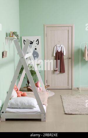 Stilvolle Schuluniform, die im Kinderzimmer an der Tür hängt Stockfoto