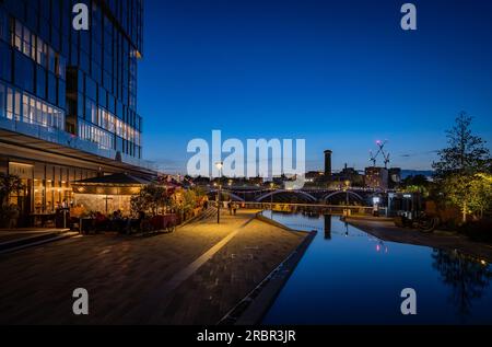 Battersea, London, Großbritannien: Teiche in einem Park und Restaurant in der Nähe des Kraftwerks Battersea. Landschaftsblick bei Nacht mit Blick nach Süden in Richtung Chelsea. Stockfoto