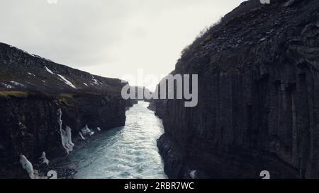 Blick aus der Vogelperspektive auf den gullfoss Cascade Canyon, majestätische nordische Landschaft mit Wasserlauf und riesigen gefrorenen Hügeln. Spektakulärer Wasserfall in island, der von den Klippen hinunterfließt. Zeitlupe. Stockfoto