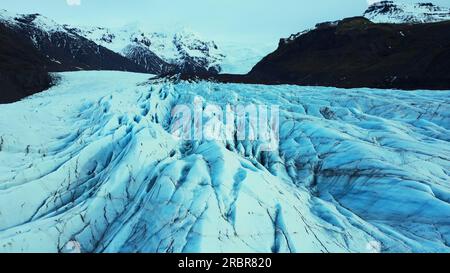 Luftaufnahme von riesigen Gletscherkappen in nordischer Landschaft, wunderschöne große vatnajokull Eisblöcke in island. Blaue Eisberge und eisige Felsen in der Nähe des gefrorenen Sees und der verschneiten Berge. Zeitlupe. Stockfoto