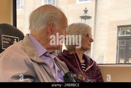 Seniorenpaar auf Behindertensitzen für ältere Menschen in öffentlichen Verkehrsmitteln Stockfoto