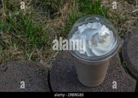 Kühlen Sie sich mit einem kalten Kaffee vor dem Hintergrund der ruhigen Schönheit der Natur ab. Stockfoto