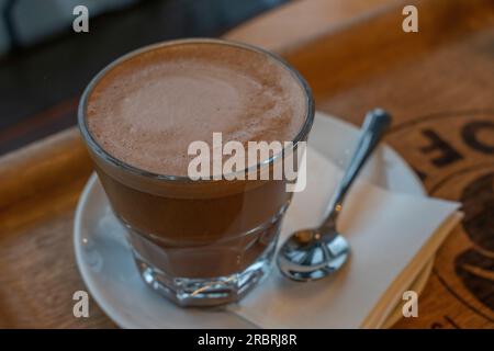 Nahaufnahme, Makroaufnahme bis heißer Espresso mit weißer Tasse auf schwarzem Holztisch, Draufsicht Stockfoto