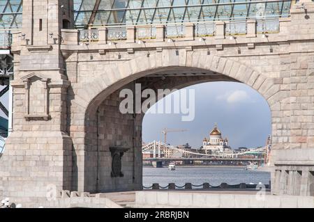 Christuskathedrale, der Erlöser, durch den Hauptbogen der Andreevsky-Eisenbahnbrücke von der Seite des Neskuchny-Gartens in Moskau, Russisch Stockfoto