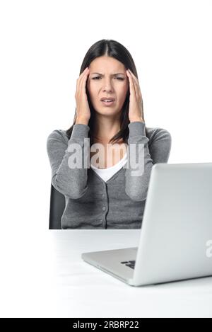Junge Frau leidet unter Headach oder Migräne mit Blick auf Laptop auf dem Tisch. isoliert auf weißem Hintergrund Stockfoto