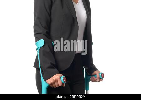 Behinderte Geschäftsfrau im schwarz-weißen Business-Anzug mit zwei Krücken, isoliert auf weißem Hintergrund Stockfoto