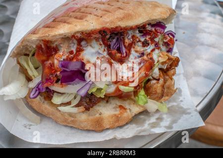 Genießen Sie ein köstliches Döner Kebab, ein beliebtes lokales Street Food, das Ihren Appetit stillen wird. Stockfoto