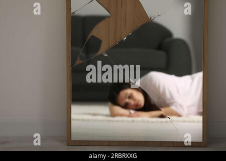 Psychische Probleme. Verschwommenes Spiegelbild einer depressiven Frau im Innenspiegel Stockfoto