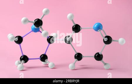 Nikotinmolekül auf pinkfarbenem Hintergrund. Chemisches Modell Stockfoto