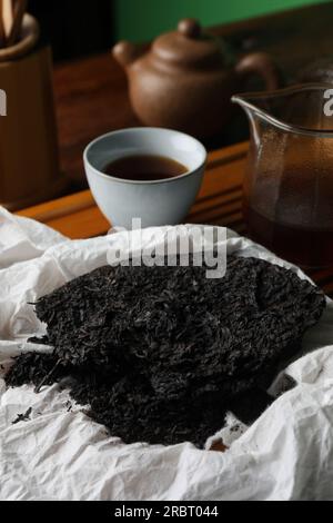 Gebrochener, scheibenförmiger pu-erh-Tee auf dem Tisch Stockfoto