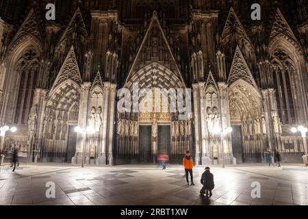 Bild des kölner Doms am Abend von unten auf der Domplatte mit Fotoaufnahmen von Touristen. Der Kölner Dom ist katholisch Stockfoto