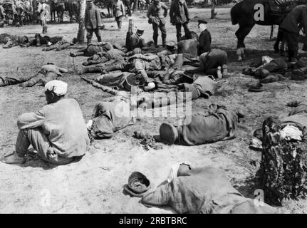 Polen: 4. August 1915 russische Soldaten, die durch die Kämpfe und die Hitze völlig erschöpft waren, lagen auf dem Boden, nachdem sie von den Deutschen auf ihrem Weg nach Warschau besiegt worden waren. Die Deutschen hatten Mitleid mit ihren Gegnern, und ihr Rotes Kreuz versorgt die Verwundeten und versorgt sie mit Wasser und feuchten Tüchern, die sie auf ihre Köpfe legen können. Stockfoto