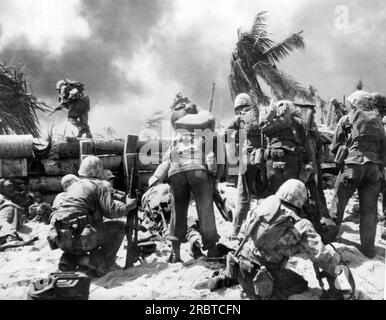 Gilbert-Inseln, Pazifik: November 1943 zwei US-Marines gehen während des Kampfes um die japanische Insel Tarawa über die japanische Mauerbefestigung. Stockfoto