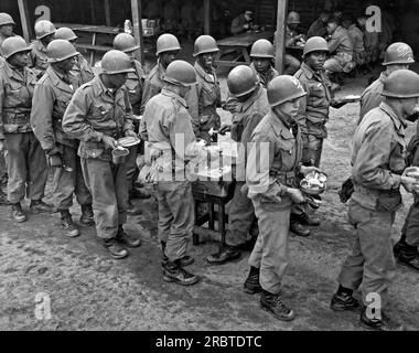 Vereinigte Staaten: c. 1940. Afroamerikanische und weiße Truppen in einer Essenslinie bei der Grundausbildung. Stockfoto