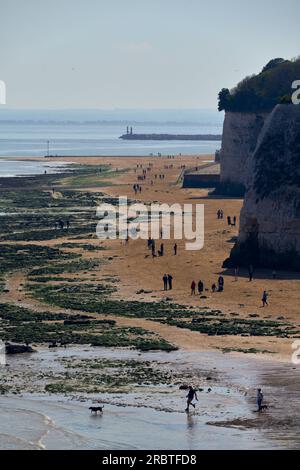 Dumpton, Großbritannien - April 29 2023 - Leute, die am Strand zwischen Broadstairs und Ramsgate spazieren gehen Stockfoto