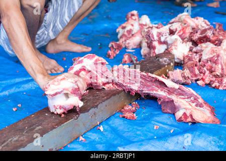 Unbekannte indonesische Moslems helfen sich gegenseitig beim Schlachten halaler Opfertiere während Eid al-Adha Stockfoto