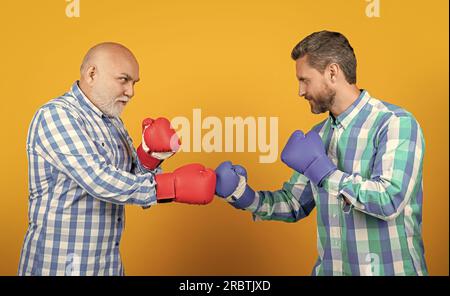 Zwei Generationen Männer Boxen isoliert auf Gelb. Generation-Männer Boxen im Studio. Stockfoto