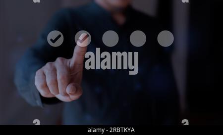 Geschäftsmann, der das Häkchen-Symbol auf dem virtuellen Bildschirm berührt. Checklistenkonzept Stockfoto