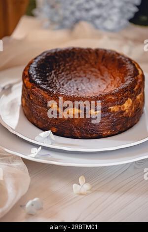 Köstlicher selbstgemachter baskischer Käsekuchen auf dem Teller aus nächster Nähe Stockfoto