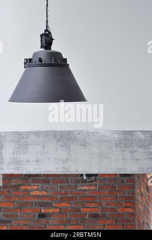 Nahaufnahme Betonwand, industrielle Loft Metall alte schwarze Lampe, schwarzes Kabel an der Wand, Industriestein, Mauerwerk, Innendesign, Kopierraum, schwarz Stockfoto
