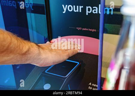 Nahaufnahme eines männlichen Handscans seiner Hand, um mit moderner drahtloser Zahlungstechnologie zu bezahlen Stockfoto