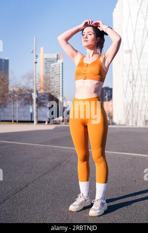 Eine Frau in Sportbekleidung, die sich auf das Laufen im Freien vorbereitet Stockfoto