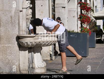 Person tanken Sie am Brunnen auf dem Loggia-Platz in Brescia mit Wasser auf Stockfoto