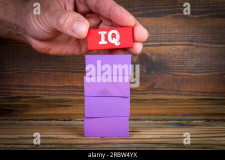 IQ-Testkonzept. Farbenfrohe Bausteine auf einem strukturierten Holzhintergrund. Stockfoto