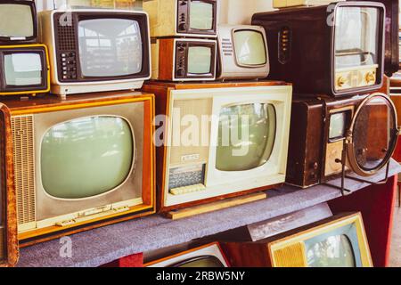 Reihen alter Fernseher. Die ersten Fernseher sind röhrenförmig. Sammlung von Retro-Fernsehgeräten. Stockfoto