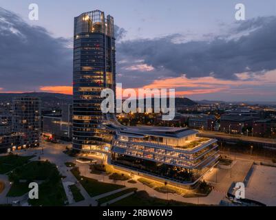 Blick aus der Vogelperspektive auf den berühmten Mol Campus, modernes Bürogebäude neben der Donau bei Sonnenuntergang. Buda-Hügel im Hintergrund. Stockfoto