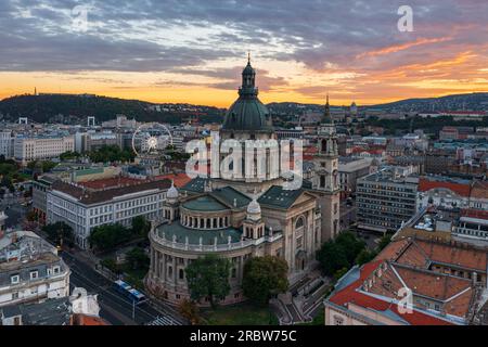 Unvergleichlicher Blick auf die Skyline des berühmten St. Stepehens Basilika in der Innenstadt von Budapest. Das Stadtbild aus der Vogelperspektive. Spektakulärer Sonnenuntergang über den Hügeln von Buda. Stockfoto