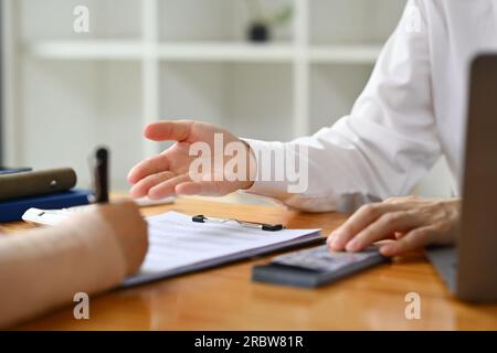 Zugeschnittenes Bild eines männlichen Bankdirektors oder Finanzberaters, der einen Kunden im Büro berät Stockfoto