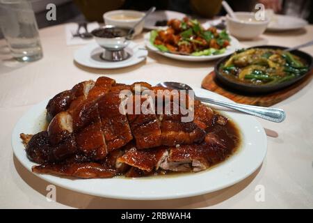 Nahaufnahme gerösteter chinesischer Honigente mit gebratenem Gemüse und orangefarbenem Hähnchen Stockfoto