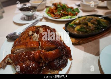 Nahaufnahme gerösteter chinesischer Honigente mit gebratenem Gemüse und orangefarbenem Hähnchen Stockfoto