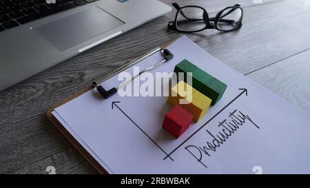 Aufsteigendes Diagramm mit TEXTPRODUKTIVITÄT auf Tisch mit Brille und Laptop. Geschäftskonzept Stockfoto
