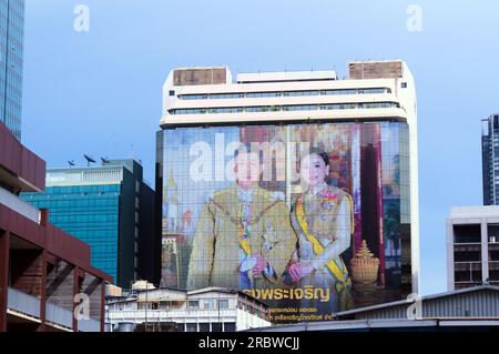 Riesenporträt von König Vajiralong korn und Königin Suthida von Thailand auf der Seite des C.P. Tower1, Bezirk Silom, Bangkok, Thailand. Thailands Ministerpräsident Prayuth Chan-ocha sagte am 11. Juli 2023, dass er sich aus der Politik zurückzieht, aber vorübergehend die Führung behalten wird. Dies geschieht, nachdem seine politische Partei, United Thai Nation, bei den Wahlen im Mai 14 einen großen Verlust erlitten hat. Die Move Forward Party, eine sozialdemokratische und fortschrittliche politische Partei, war der größte Wahlsieger. Am 13. Juli 2023 bereitet sich das neue Parlament darauf vor, eine Abstimmung darüber abzuhalten, wer der nächste Premierminister sein wird. Stockfoto