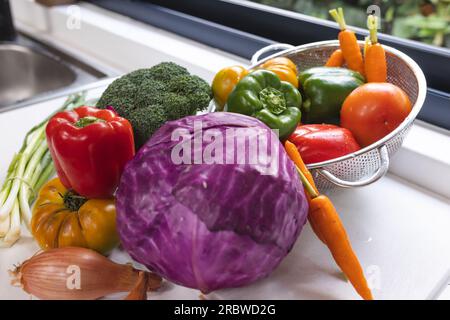 Nahaufnahme von farbenfrohem Gemüse auf der weißen Arbeitsplatte in der Küche Stockfoto