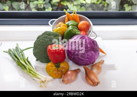 Nahaufnahme von farbenfrohem Gemüse auf der weißen Arbeitsplatte in der Küche Stockfoto