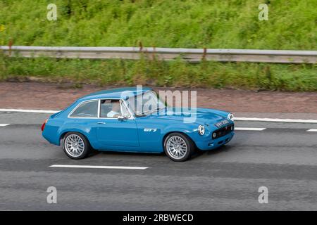 1978 70s Siebzigerjahre modifiziert Blue MG B GT; Fahrt mit hoher Geschwindigkeit auf der Autobahn M6 im Großraum Manchester, Großbritannien Stockfoto
